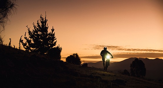 Man riding in dark on bike with headlight
